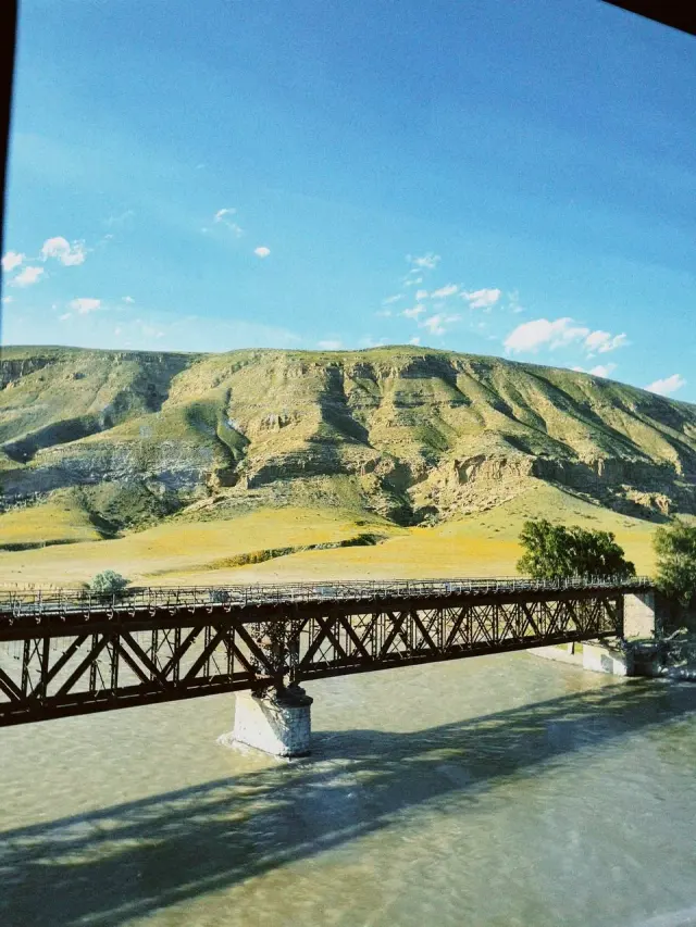 A bridge across a river beneath dry hills