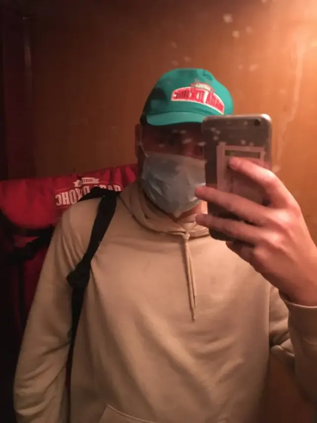 Alexey taking a mirror portrait in a cap and face mask
